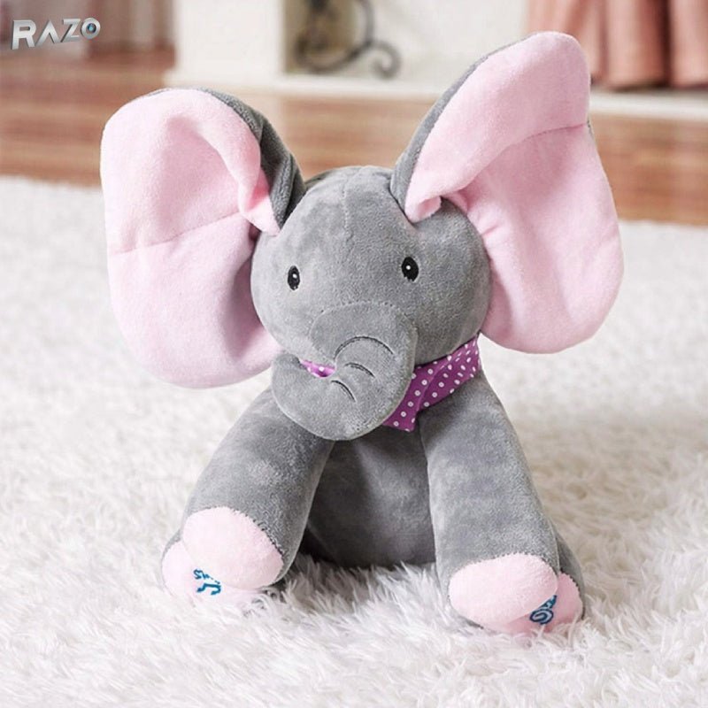 Jucarie interactiva RAZO din plus elefant Cucu-Bau, muzicala, canta si vorbeste in limba engleza, functie peekaboo cu urechi mobile, dimensiuni 30x25 cm, roz